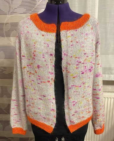 Hellgrauer Pullover mit bunten Sprenkeln und orangefarbenem Kragen.