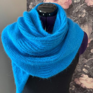 Blauer, weicher Schal, drapiert um eine Mannequin-Schulter.