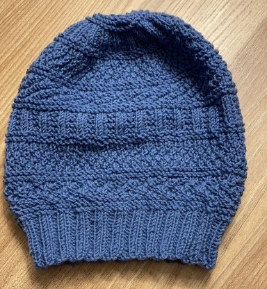 Dunkelblaue gestrickte Mütze mit Struktur und breitem Bündchen.