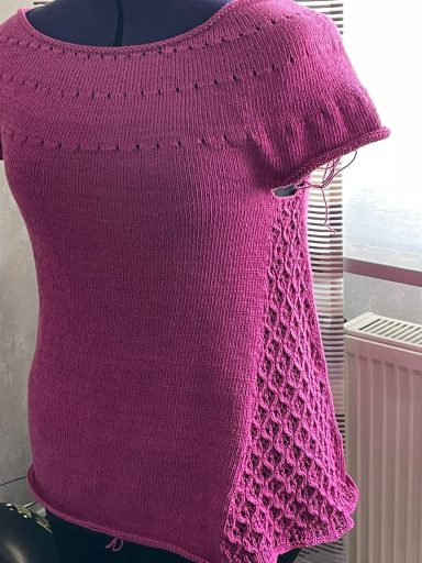 Rosa, kurzärmliges Strickshirt mit Lochmuster an den Seiten.