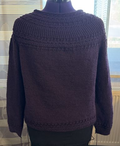 Dunkellila Strickpullover mit Rundhalsausschnitt und weitem Schnitt.