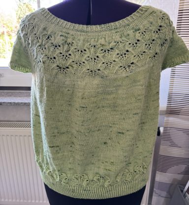 Damenoberteil in hellem Grün mit Spitzenmuster am Ausschnitt und Saum.