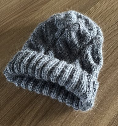 Grau gestrickte Mütze mit einem doppelten, gerippten Bund.